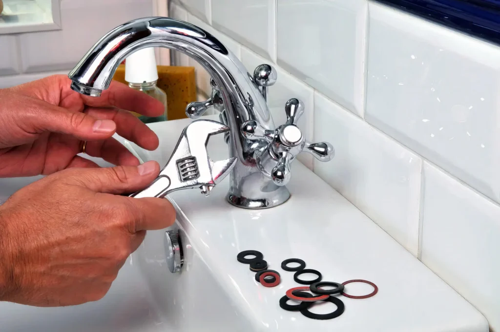 Plumber performing maintenance on a bathroom faucet in Wheat Ridge