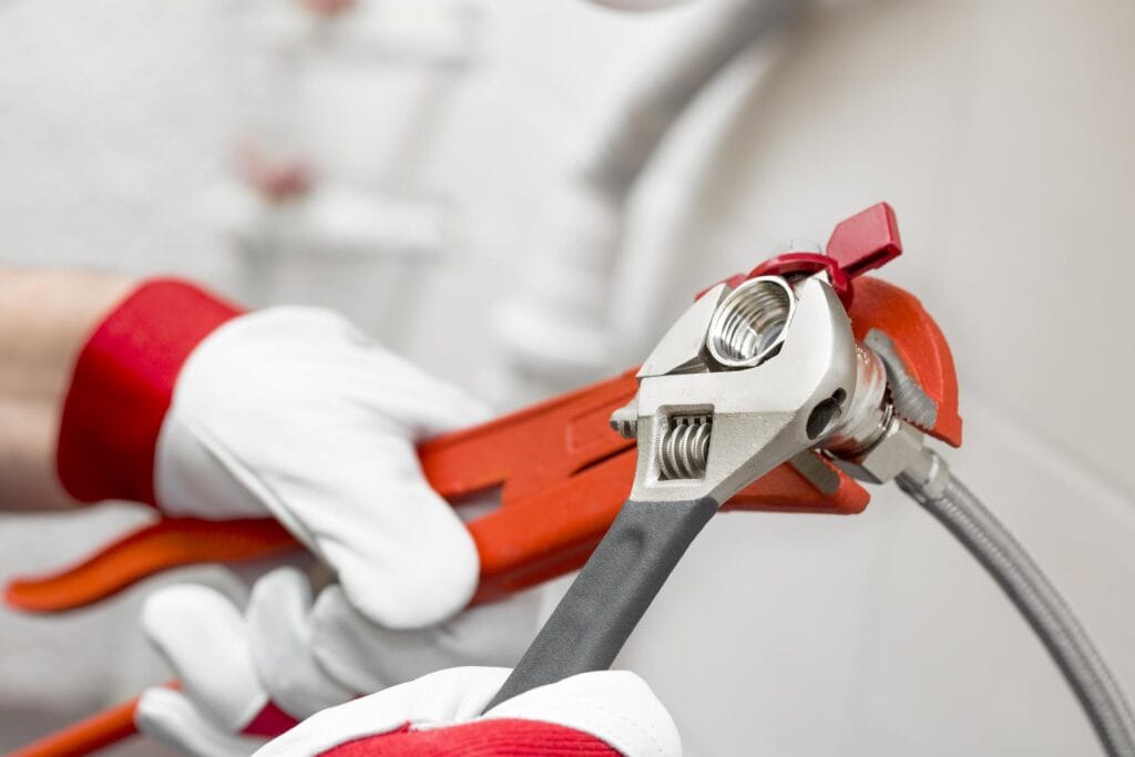 Plumber holding pipe wrenches for an emergency repair in Wheat Ridge