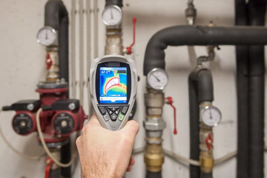 Plumber using a thermal imaging camera to inspect pipes in Wheat Ridge
