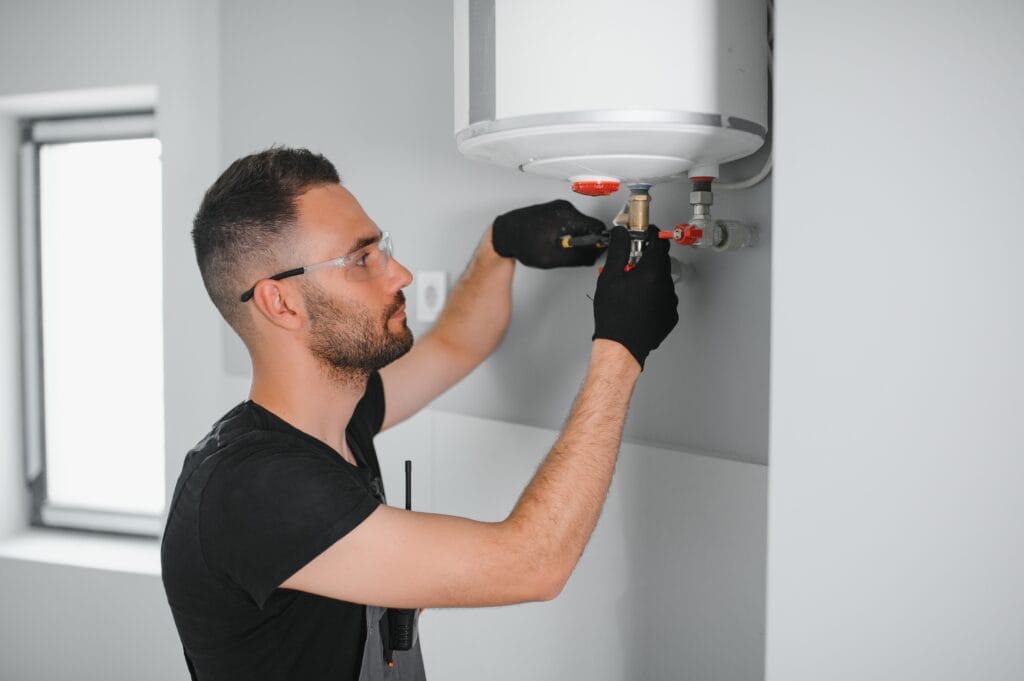 Technician performing water heater maintenance in Wheat Ridge