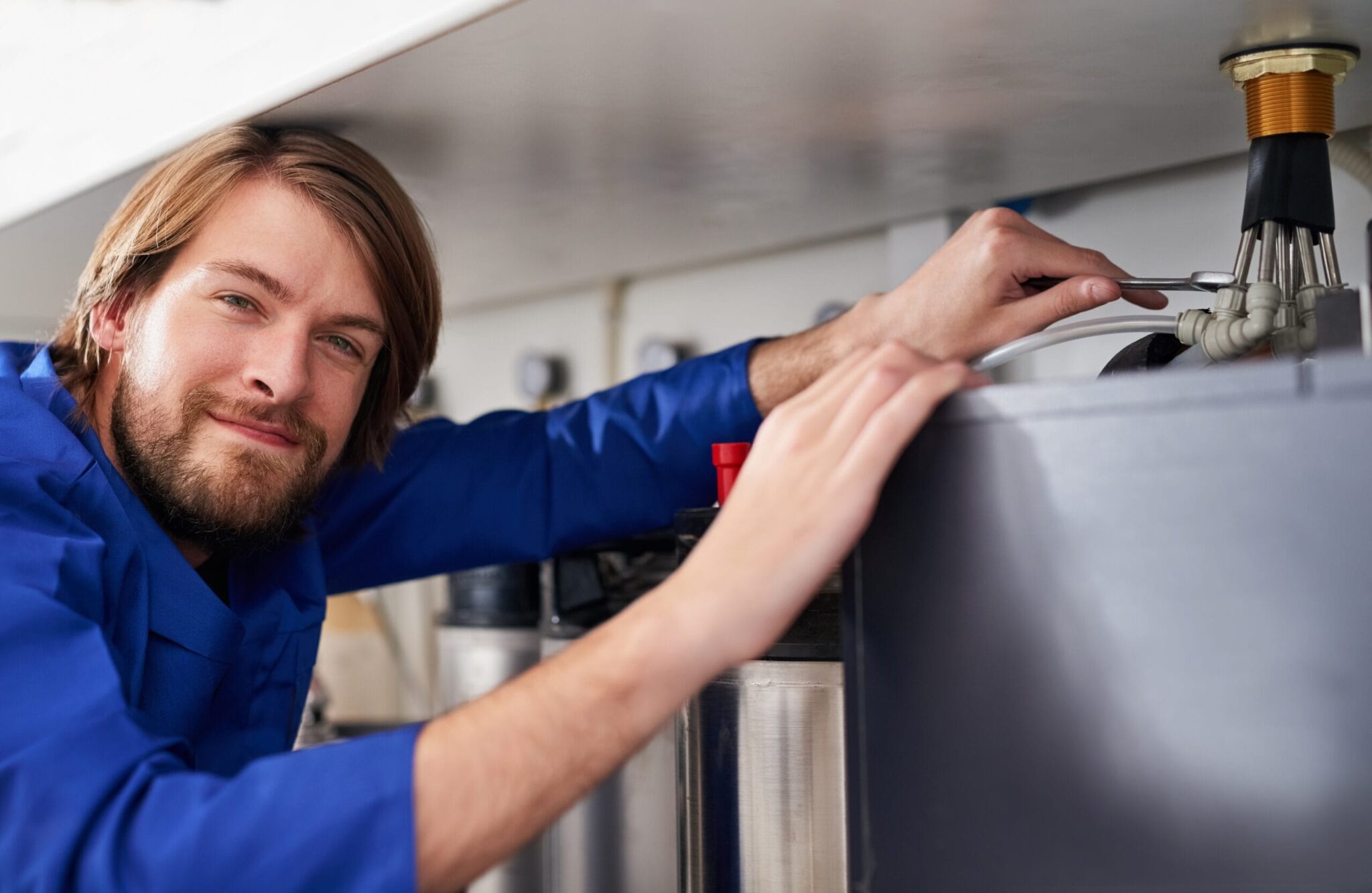 Technician servicing a residential water heater tank in Wheat Ridge